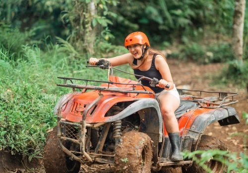 excited asian woman screaming while riding the atv through the difficult way at atv arena