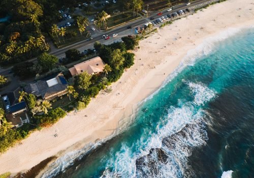An aerial shot of houses and roads near the sandy beach