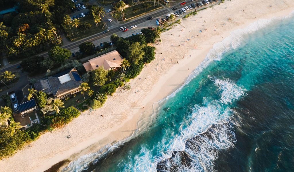 An aerial shot of houses and roads near the sandy beach