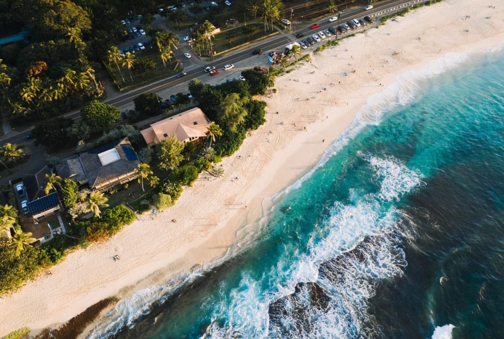 An aerial shot of houses and roads near the sandy beach